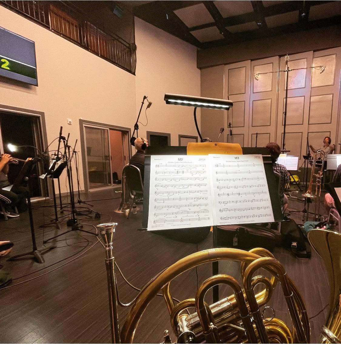 Horn, music stand and musicians during an orchestral recording session
