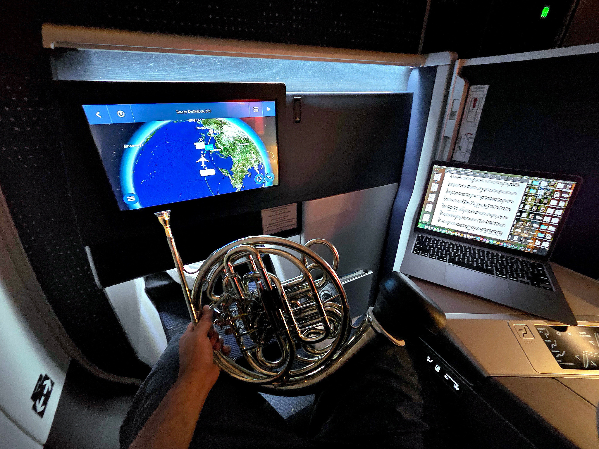 French horn and sheet music aboard an international flight